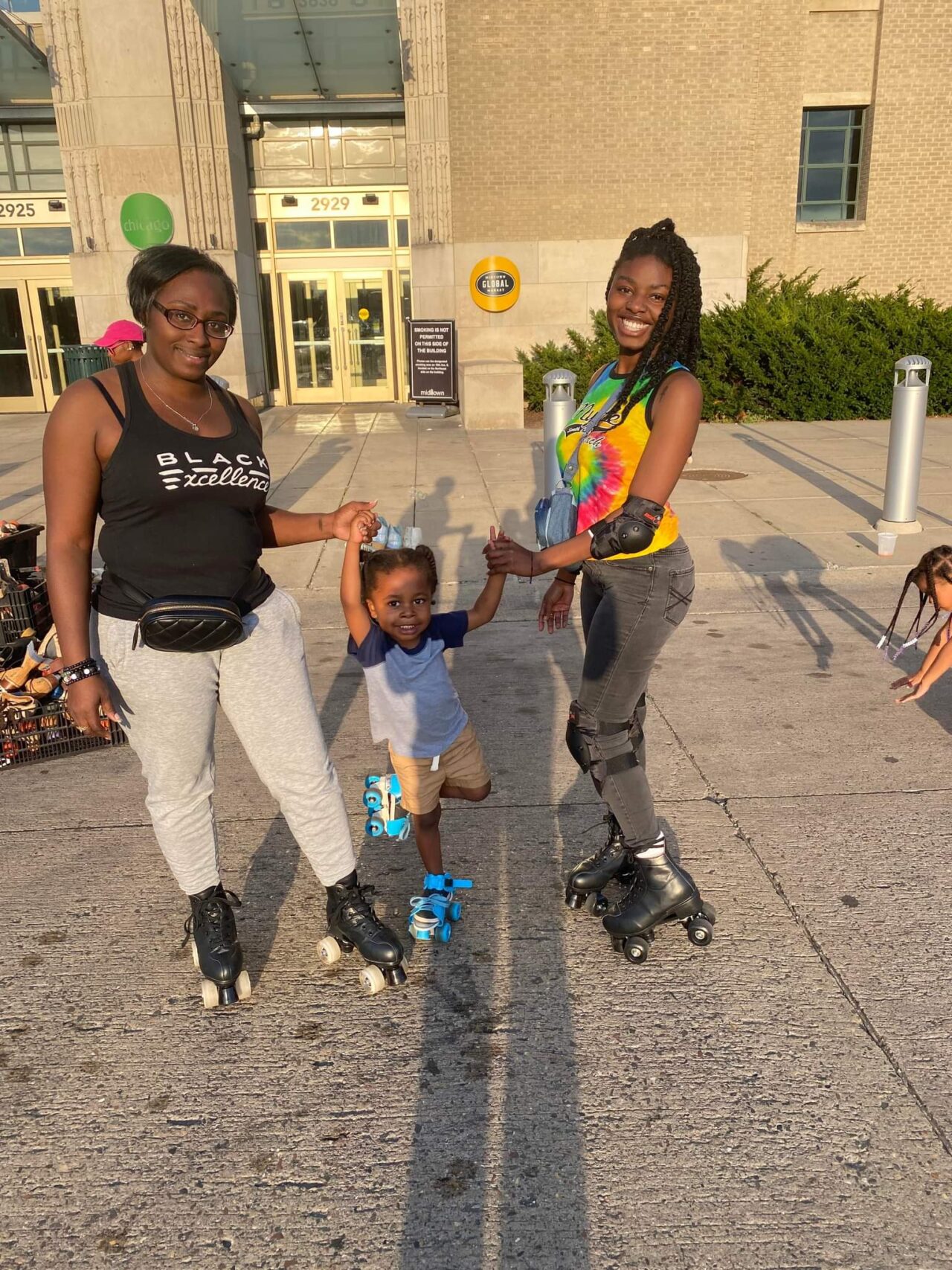 Family of 2 adults and one child having fun rollerskating